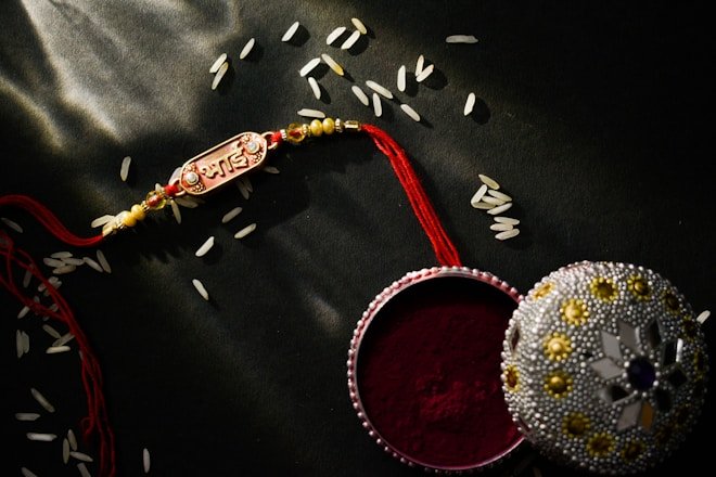 a red and white container with a red string and a red and gold beaded. Online Deals List